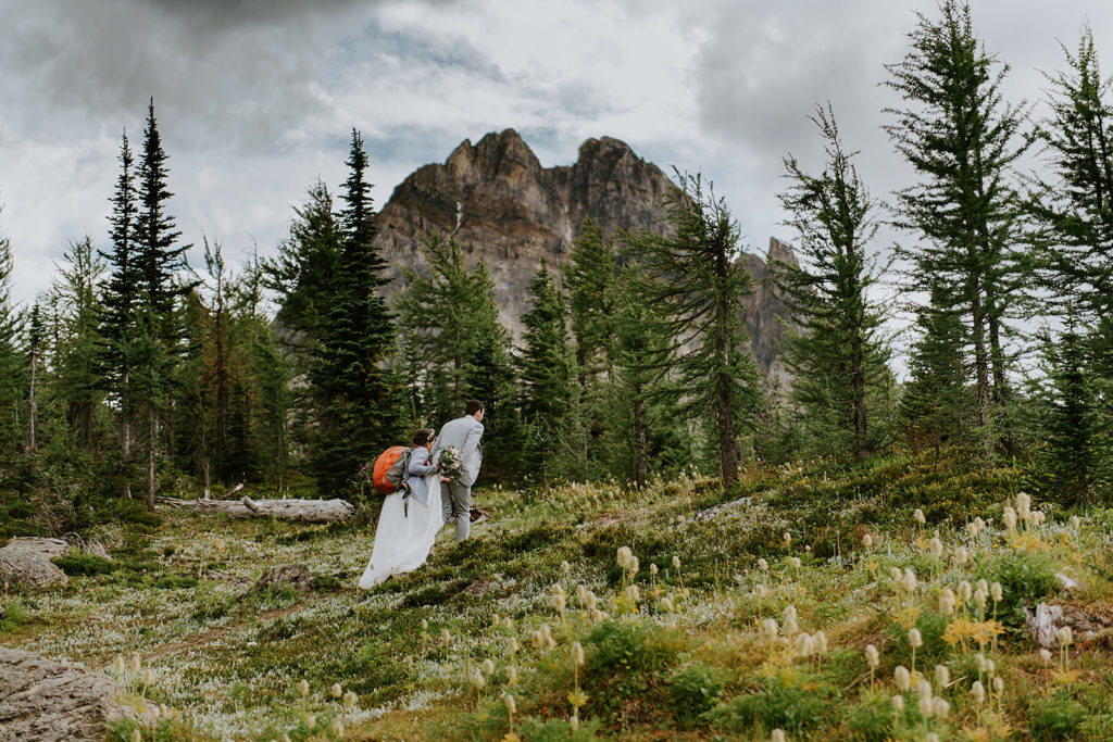 Couple hiking to their B.C elopement location with their B.C elopement photographer