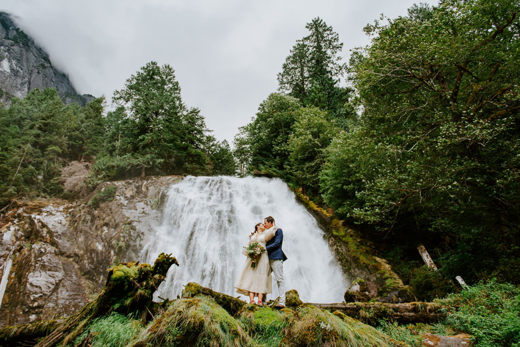 Couple celebrating in front of Chatterbox Falls during their British Columbia Elopement Package.