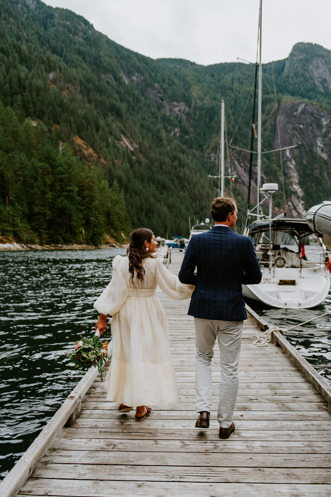Couple walking on the dock at Chatterbox Falls in the Princess Louisa Marine Provincial Park during their British Columbia Elopement Package.