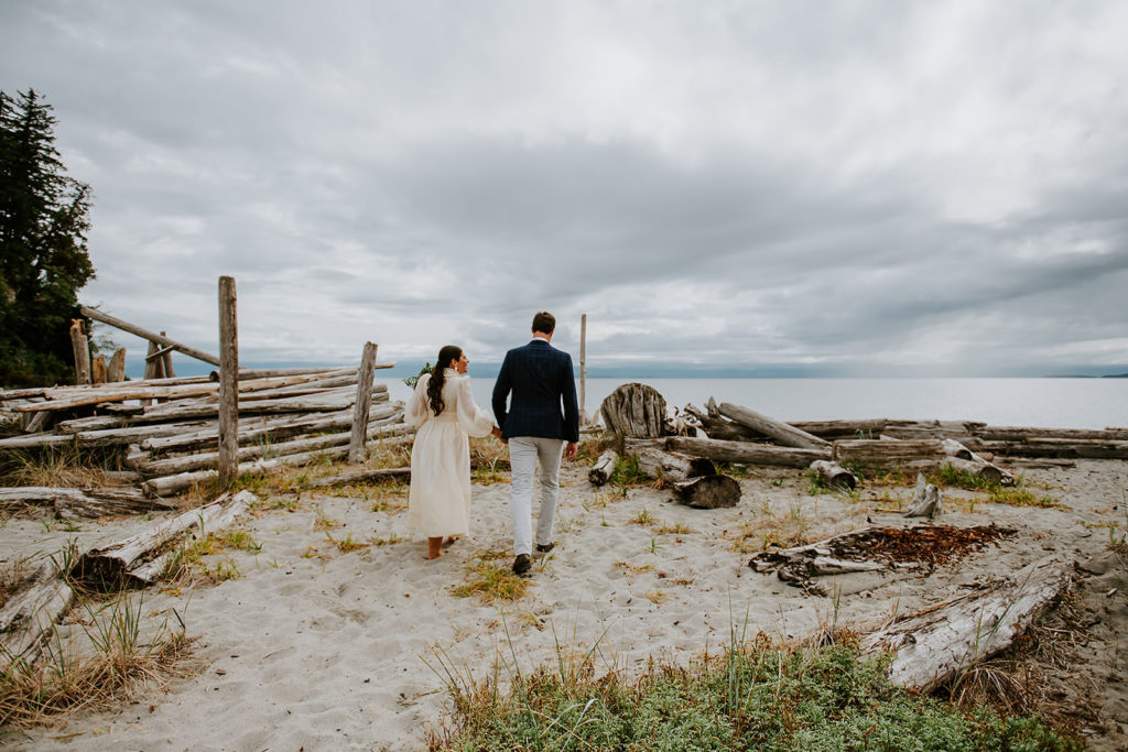 Couple walking on the sandy shores of Thormanby Island during their British Columbia Adventure Elopement Package