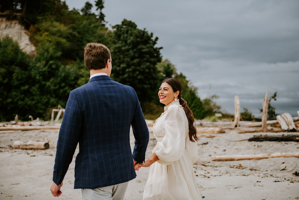 Couple walking on the sandy shores of Thormanby Island during their British Columbia Adventure Elopement Package