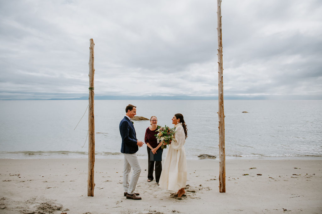Couple during their wedding ceremony on the sandy shores of Thormanby Island during their British Columbia Adventure Elopement Package