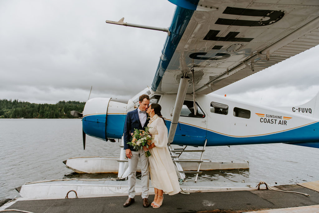 Couple standing in front of their Sunshine Coast Air seaplane during their British Columbia Adventure Elopement.