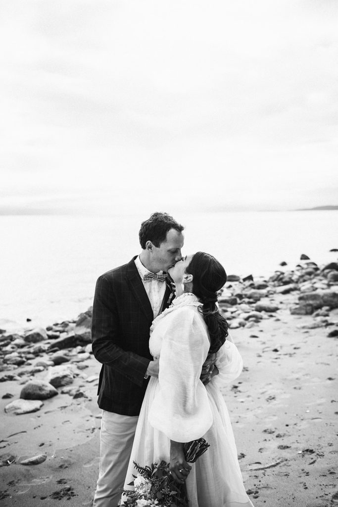 Couple kissing on the sandy shores of Thormanby Island during their British Columbia Adventure Elopement Package