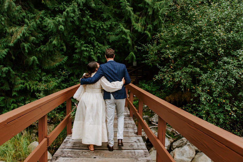 Couple walking on the dock of Chatterbox Falls in the Princess Louisa Marine Provincial Park during their British Columbia Elopement Package.
