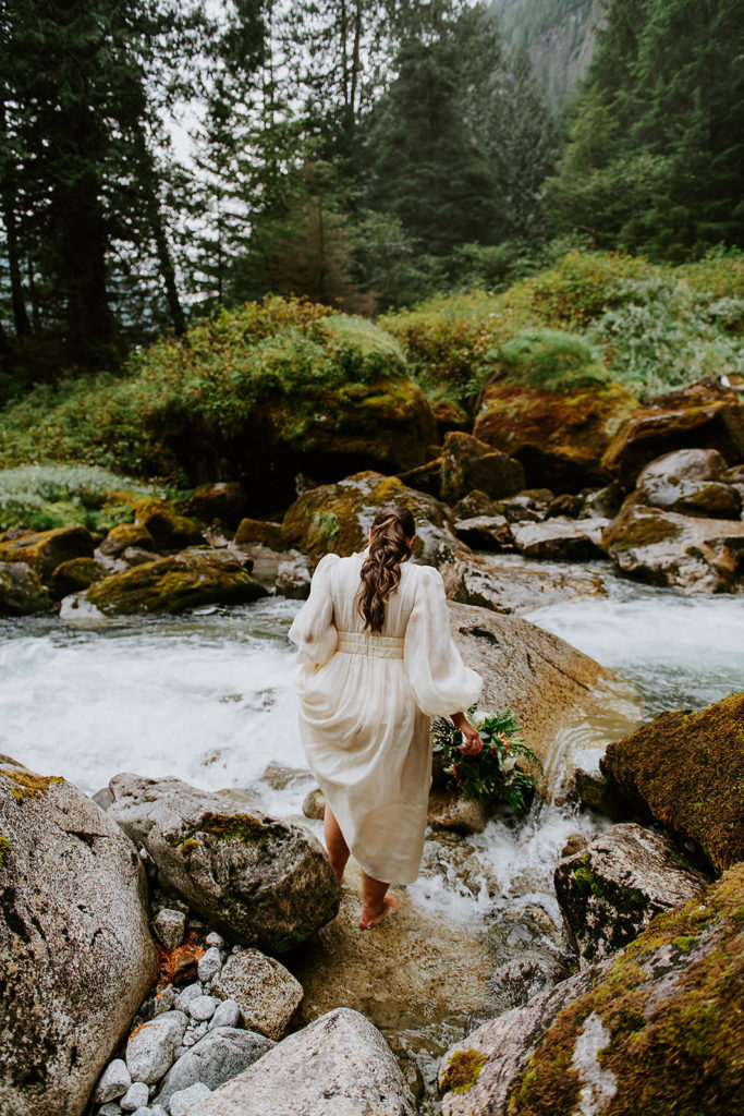 Bride standing in the waters of Chatterbox Falls in the Princess Louisa Marine Provincial Park during her British Columbia Elopement Package.