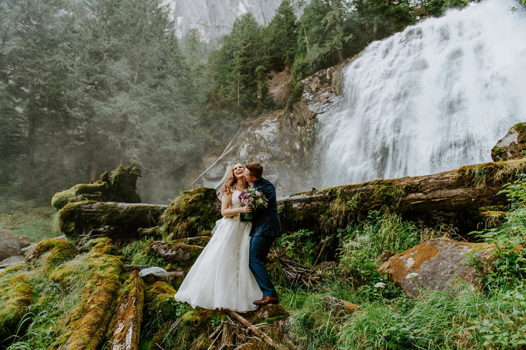Couple celebrating during their waterfall elopement at Chatterbox falls with their B.C elopement photographer.